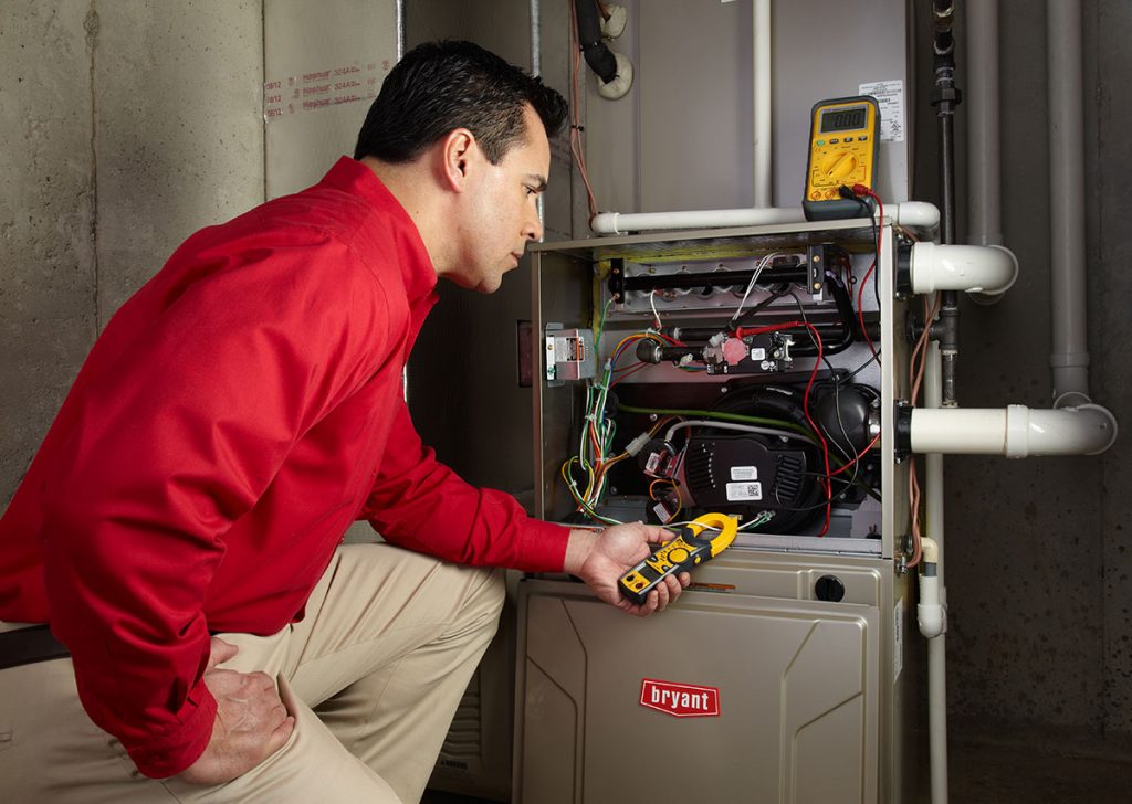 Heating and air conditioning technician servicing an indoor furnace in Thornton, CO