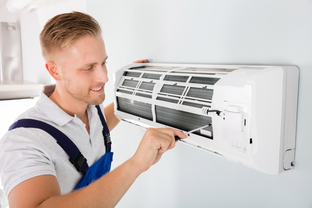 HVAC technician performing ductless air conditioning maintenance in Thornton