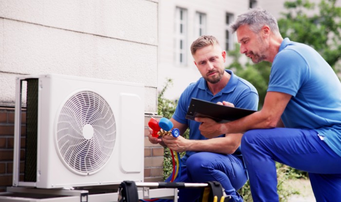 HVAC technicians installing an outdoor air conditioning unit in Thornton