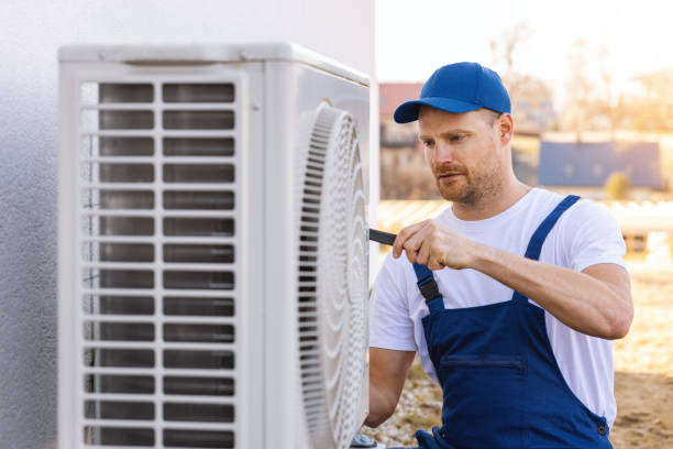 HVAC technician servicing an outdoor air conditioning unit in Thornton