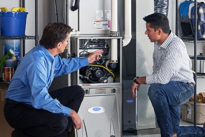 HVAC technician explaining furnace repair and maintenance to a homeowner in Thornton, CO