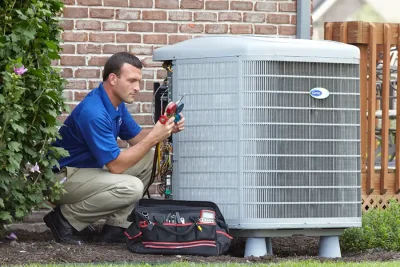 HVAC technician inspecting an outdoor air conditioning unit in Thornton, CO