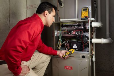 Heating and air conditioning technician servicing an indoor furnace in Thornton, CO
